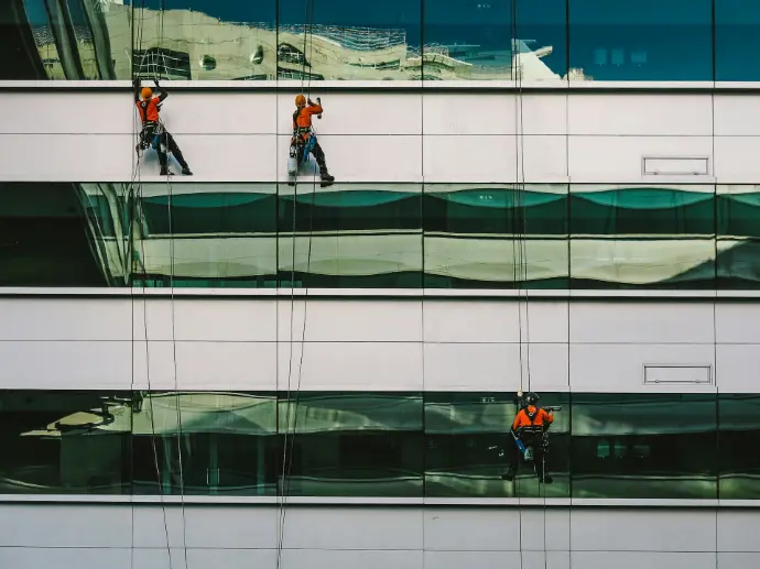 man cleaning white building